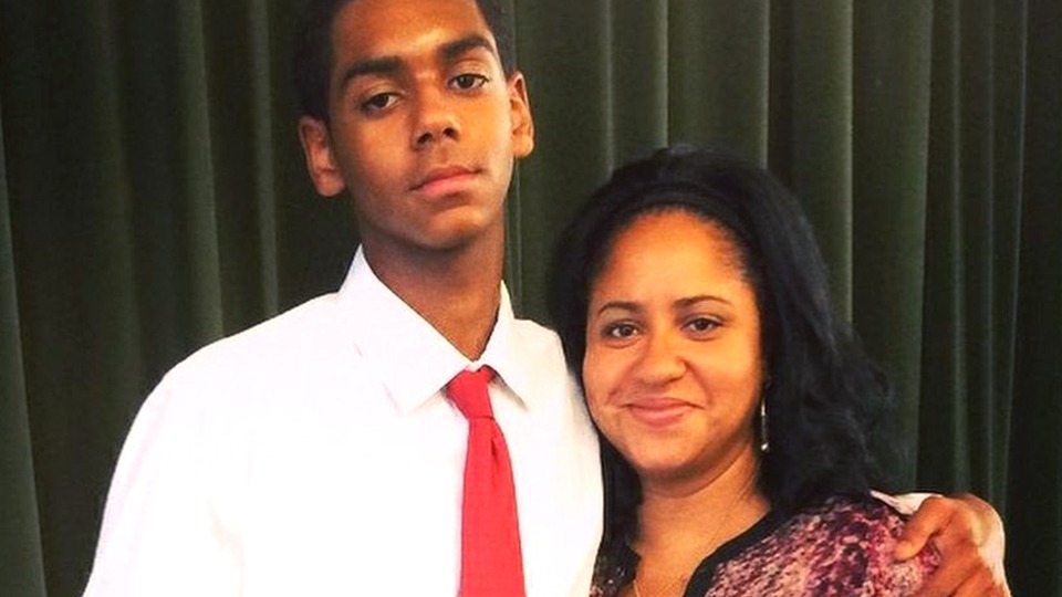 Laurie Holmond smiling proudly next to her son Julian Corrie Broadus at a formal graduation celebration.