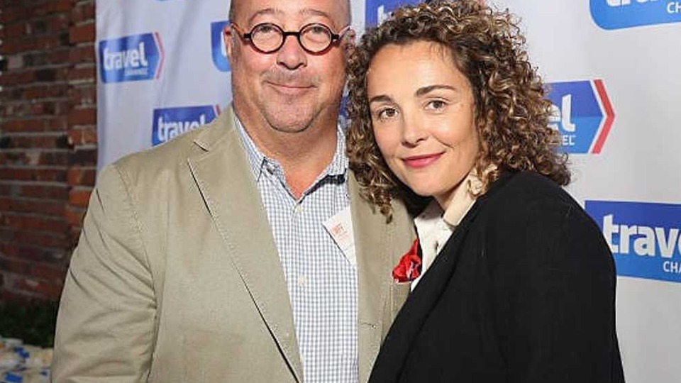 Rishia Haas and Andrew Zimmern standing together at an evening television network event in Minneapolis.